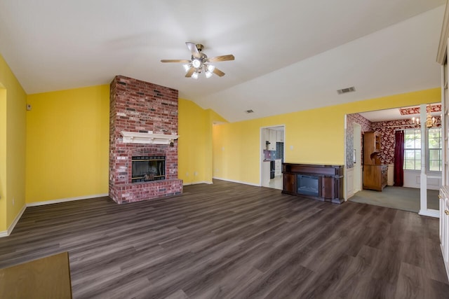 unfurnished living room with a brick fireplace, ceiling fan, vaulted ceiling, and dark wood-type flooring