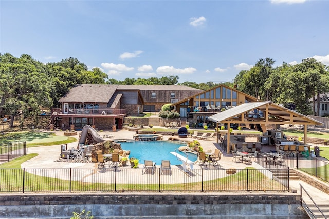 view of pool featuring a patio, exterior bar, an in ground hot tub, a yard, and a gazebo