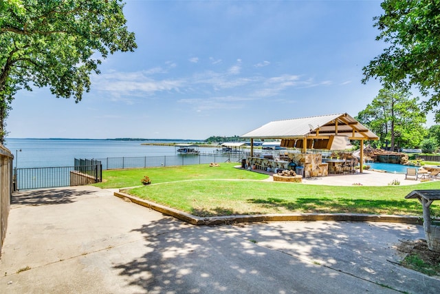 view of yard with a water view, an outdoor bar, and a patio area