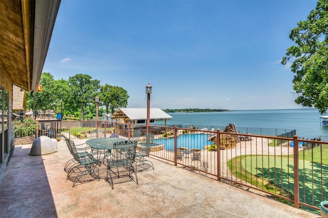 view of patio / terrace featuring a fenced in pool and a water view