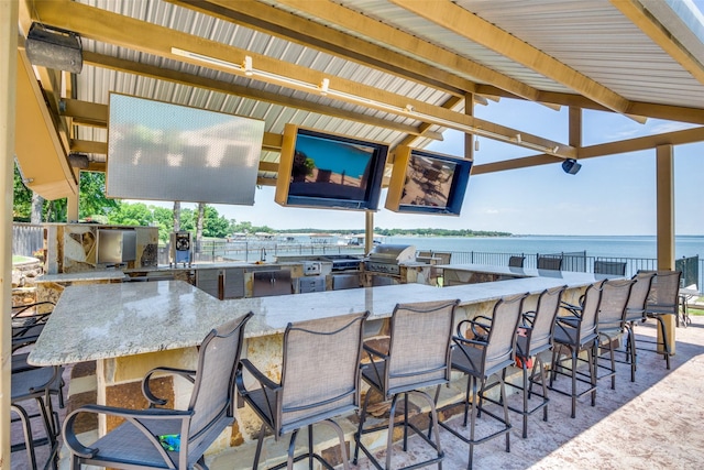 view of patio with exterior kitchen, a grill, and a bar