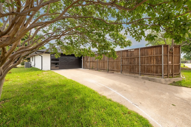 view of yard featuring a garage and central AC unit