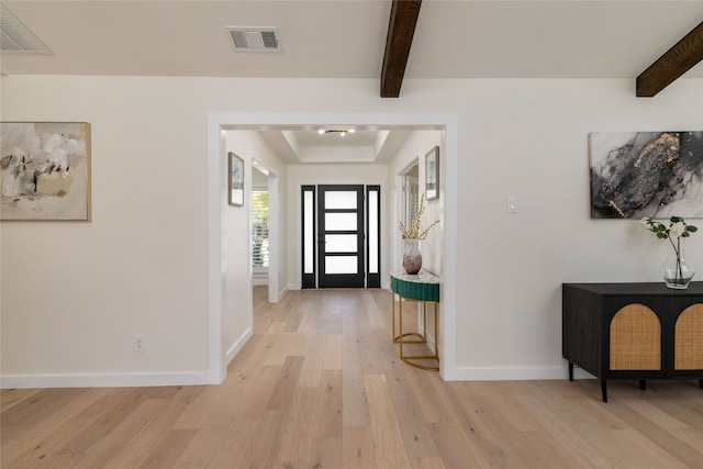 foyer entrance featuring beamed ceiling and light wood-type flooring