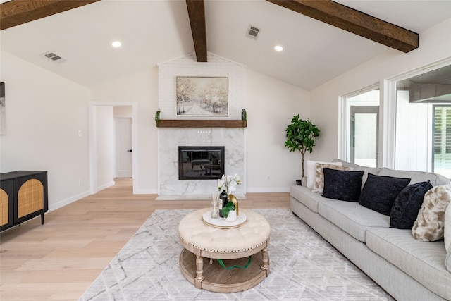 living room featuring hardwood / wood-style floors, vaulted ceiling with beams, and a fireplace