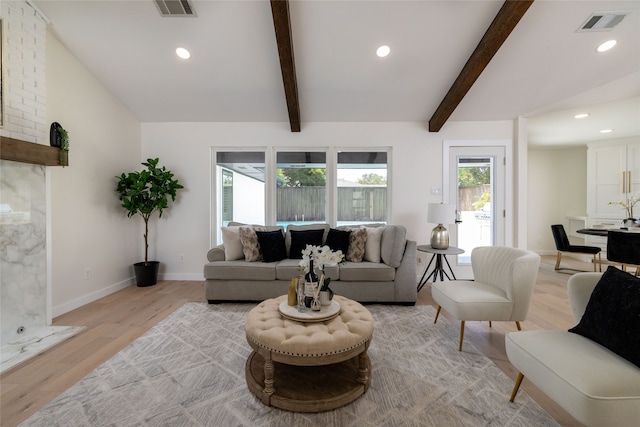 living room with vaulted ceiling with beams and light wood-type flooring