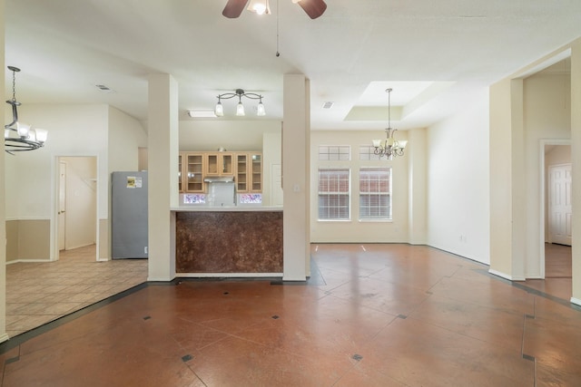 interior space featuring tile patterned floors, a tray ceiling, and ceiling fan with notable chandelier