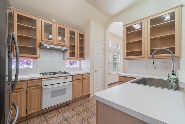 kitchen featuring decorative backsplash, sink, light tile patterned flooring, and stainless steel appliances