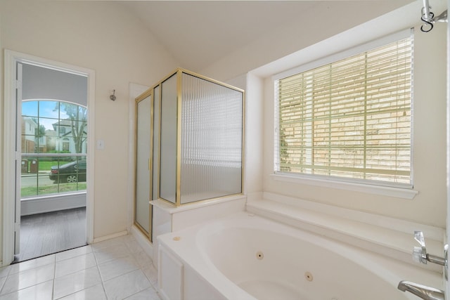 bathroom with tile patterned flooring, vaulted ceiling, and plus walk in shower