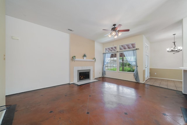 unfurnished living room featuring tile patterned flooring, ceiling fan with notable chandelier, and a tiled fireplace