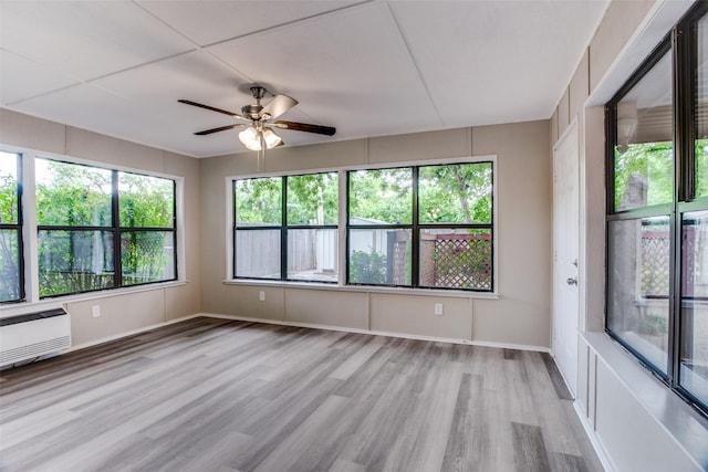 unfurnished sunroom with ceiling fan