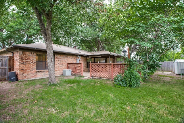 back of house featuring a lawn and central air condition unit