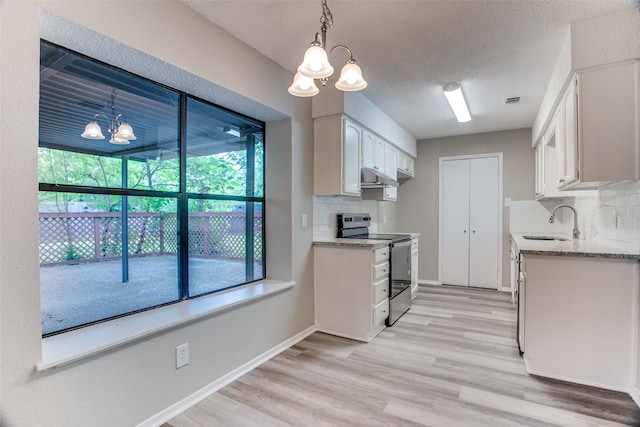 kitchen featuring white cabinets, electric range, tasteful backsplash, decorative light fixtures, and a chandelier