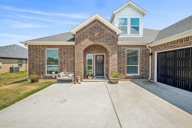 view of front of home with a garage and central air condition unit