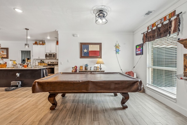 recreation room with billiards, sink, light hardwood / wood-style floors, and crown molding