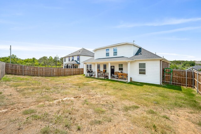 rear view of house featuring a lawn and a patio area