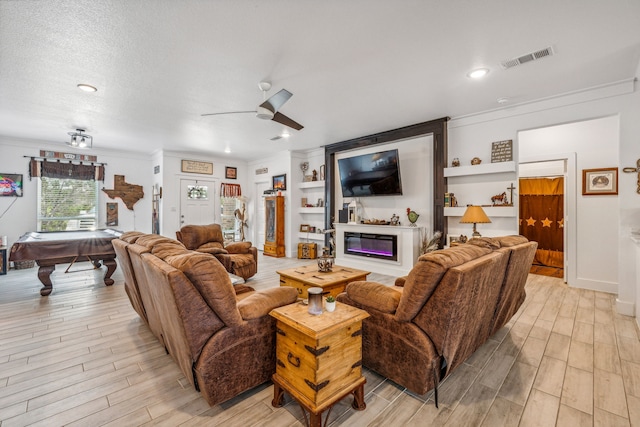 living room featuring crown molding, a textured ceiling, light hardwood / wood-style flooring, pool table, and ceiling fan