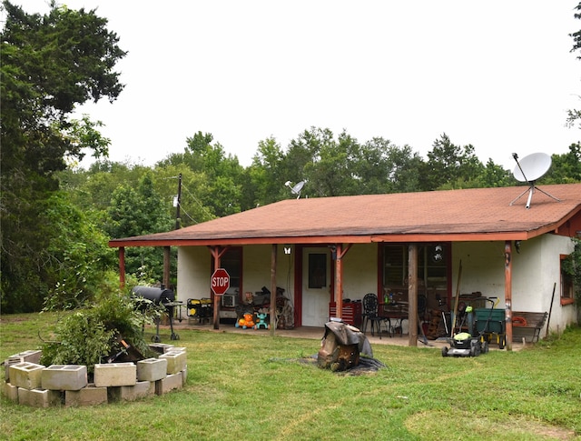 rear view of house featuring a lawn and a patio