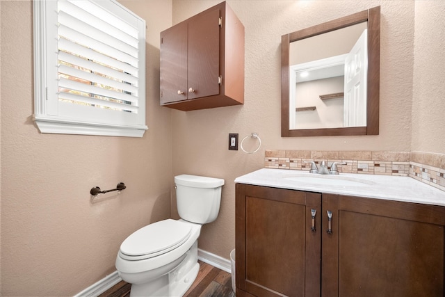 bathroom with toilet, vanity, and hardwood / wood-style flooring