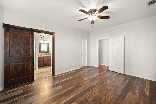 tiled empty room featuring ceiling fan and a barn door