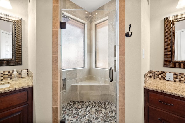 bathroom featuring backsplash, vanity, and a shower with shower door