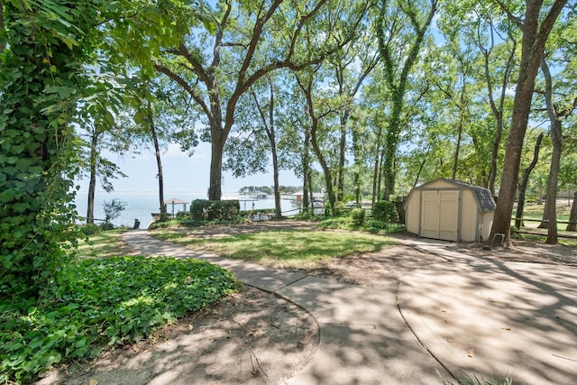 exterior space featuring a storage shed and a water view