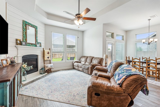 living room featuring ceiling fan with notable chandelier and light hardwood / wood-style floors