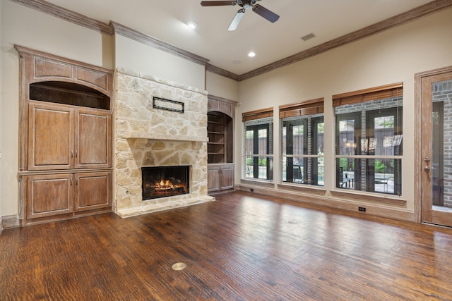 unfurnished living room featuring ceiling fan, crown molding, a fireplace, and dark wood-type flooring