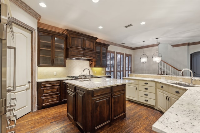 kitchen featuring cream cabinetry, dark brown cabinetry, sink, and dark wood-type flooring