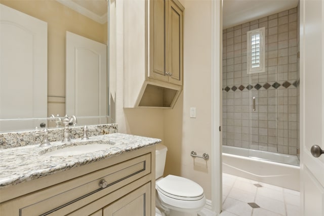 full bathroom featuring tile patterned floors, ornamental molding, vanity, toilet, and tiled shower / bath