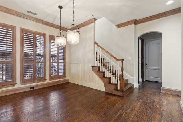 interior space featuring a notable chandelier, plenty of natural light, ornamental molding, and dark wood-type flooring