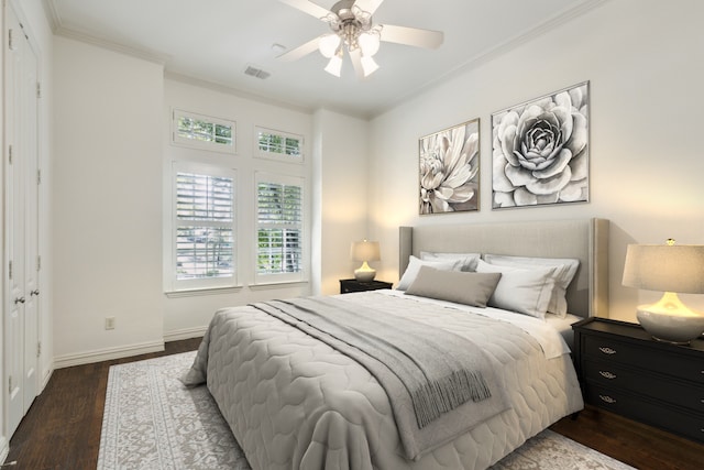 bedroom featuring ceiling fan, dark hardwood / wood-style flooring, crown molding, and a closet