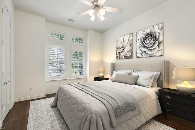 bedroom featuring crown molding, dark wood-type flooring, and ceiling fan