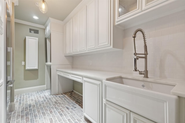 clothes washing area with crown molding and sink