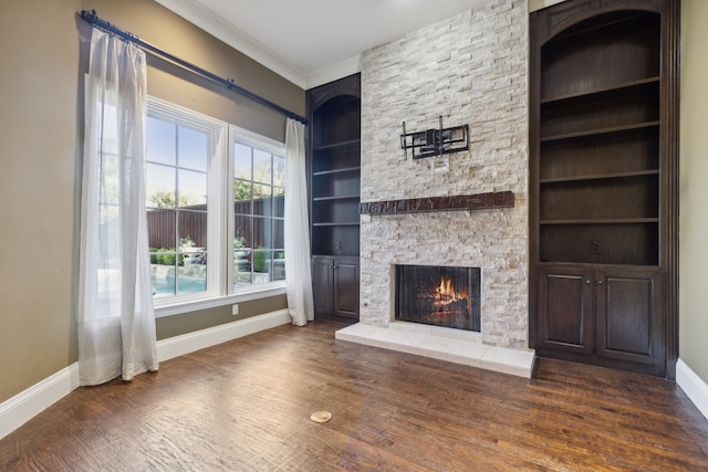 unfurnished living room featuring a fireplace, built in shelves, dark wood-type flooring, and ornamental molding