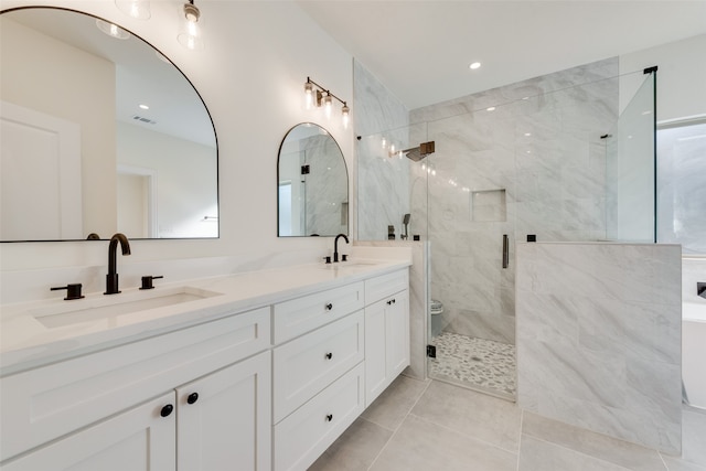 bathroom with walk in shower, vanity, and tile patterned floors