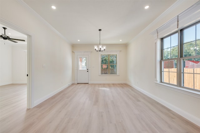 empty room featuring ceiling fan with notable chandelier, ornamental molding, and light hardwood / wood-style flooring