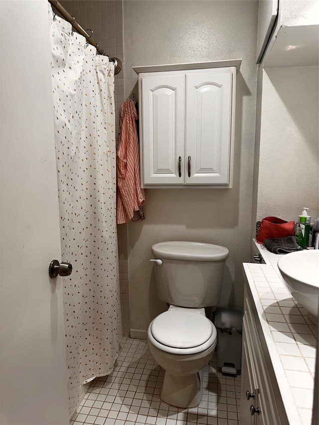 full bath featuring curtained shower, vanity, toilet, and tile patterned floors