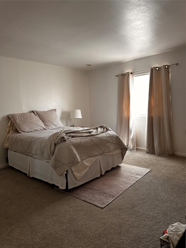 bedroom featuring carpet floors and a textured ceiling