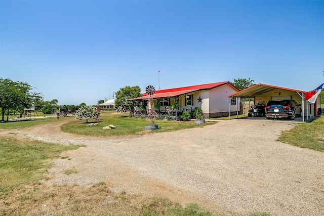 view of front of house featuring covered porch, a front yard, and a carport