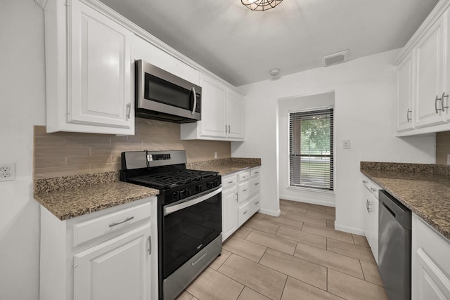 kitchen with white cabinetry, backsplash, dark stone countertops, light tile patterned flooring, and appliances with stainless steel finishes