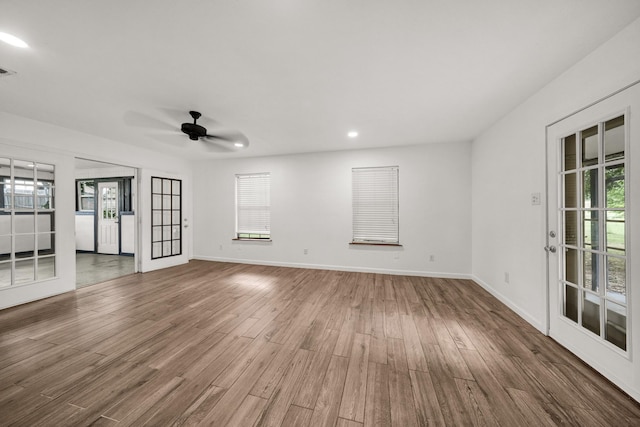 unfurnished room featuring hardwood / wood-style floors, plenty of natural light, and ceiling fan