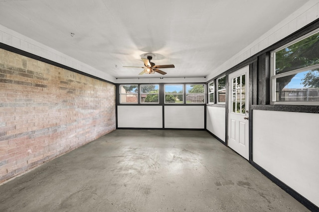 unfurnished sunroom featuring ceiling fan