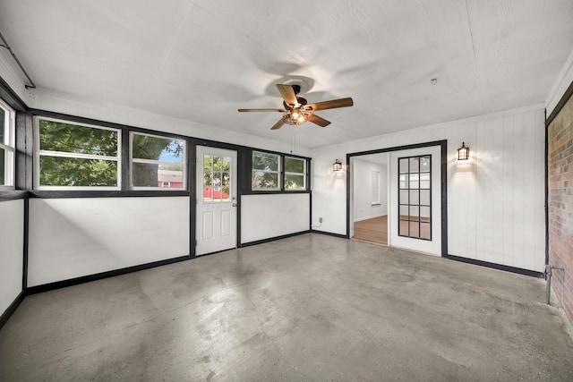 unfurnished room with ceiling fan and concrete floors