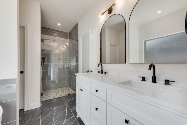 bathroom featuring a shower with shower door and vanity