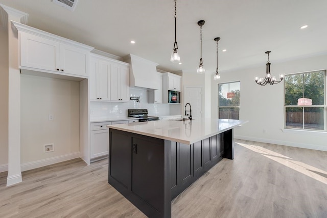 kitchen with white cabinets, a large island with sink, stainless steel electric range oven, and pendant lighting