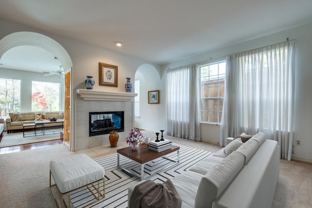 living room with ceiling fan, a fireplace, and light colored carpet