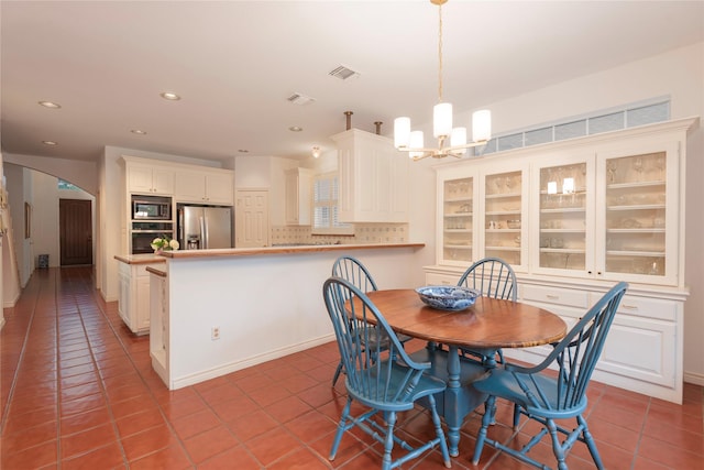 tiled dining space with a notable chandelier