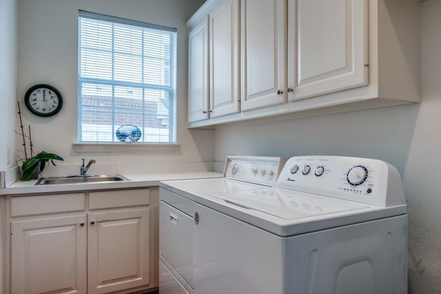 laundry area with cabinets, washing machine and dryer, sink, and a wealth of natural light