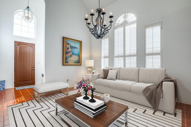 living room featuring light tile patterned flooring, high vaulted ceiling, and an inviting chandelier