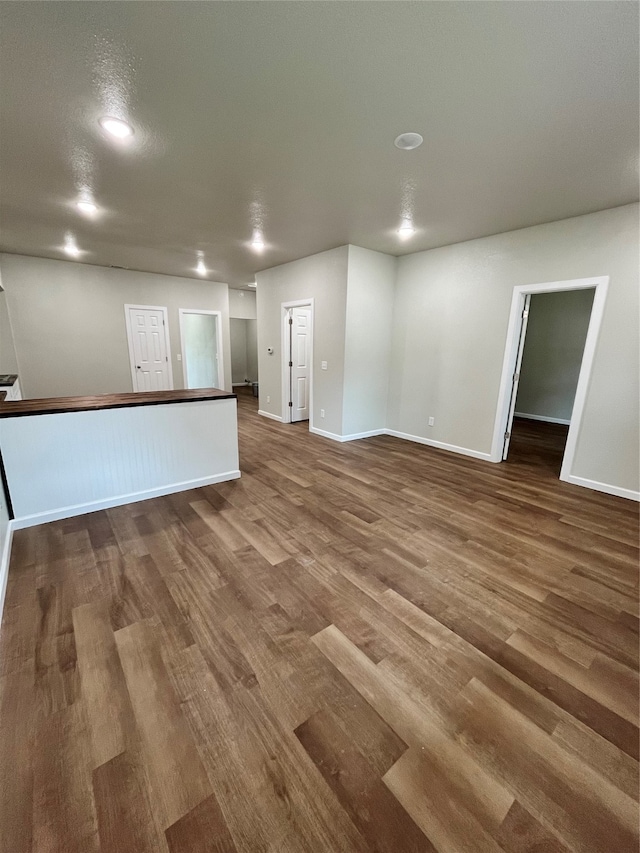 unfurnished living room featuring dark wood-type flooring